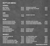 a black and white menu with a bottle of liquor on it